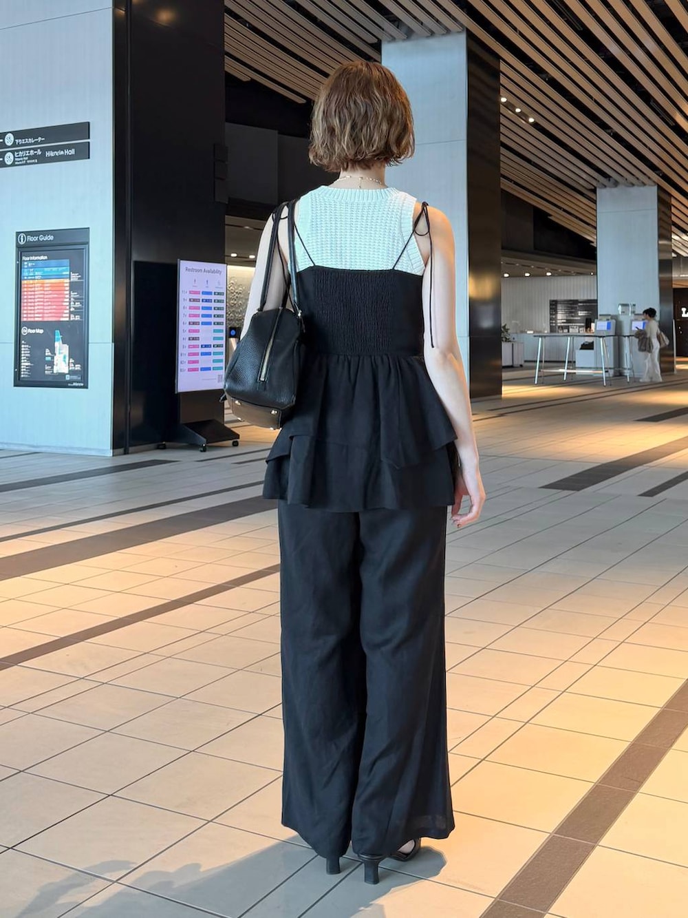 ブラック系のハンドバッグ、ブラック系のサンダル、ブラック系のシャツ/ブラウスを着用したレディースの春コーディネートの3枚目の写真