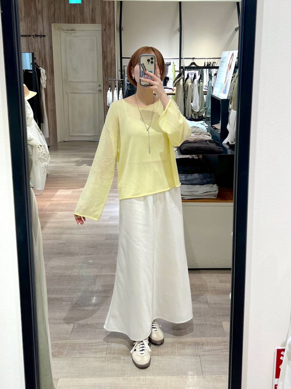 イエロー系のニット/セーター、グレー系のテーラードジャケット、ホワイト系のスカートを着用したレディースの春コーディネートの8枚目の写真