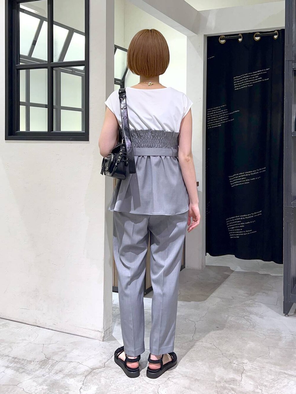 ブラック系のサンダル、グレー系のその他パンツ、グレー系のTシャツ/カットソーを着用したレディースの春コーディネートの3枚目の写真