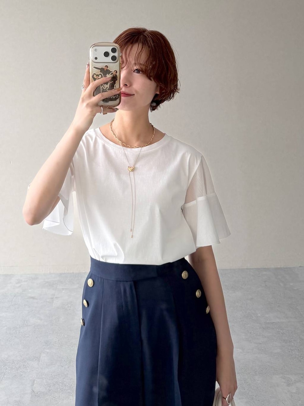ホワイト系のショルダーバッグ、ホワイト系のTシャツ/カットソー、ブラック系のサンダルを着用したレディースの春コーディネートの6枚目の写真