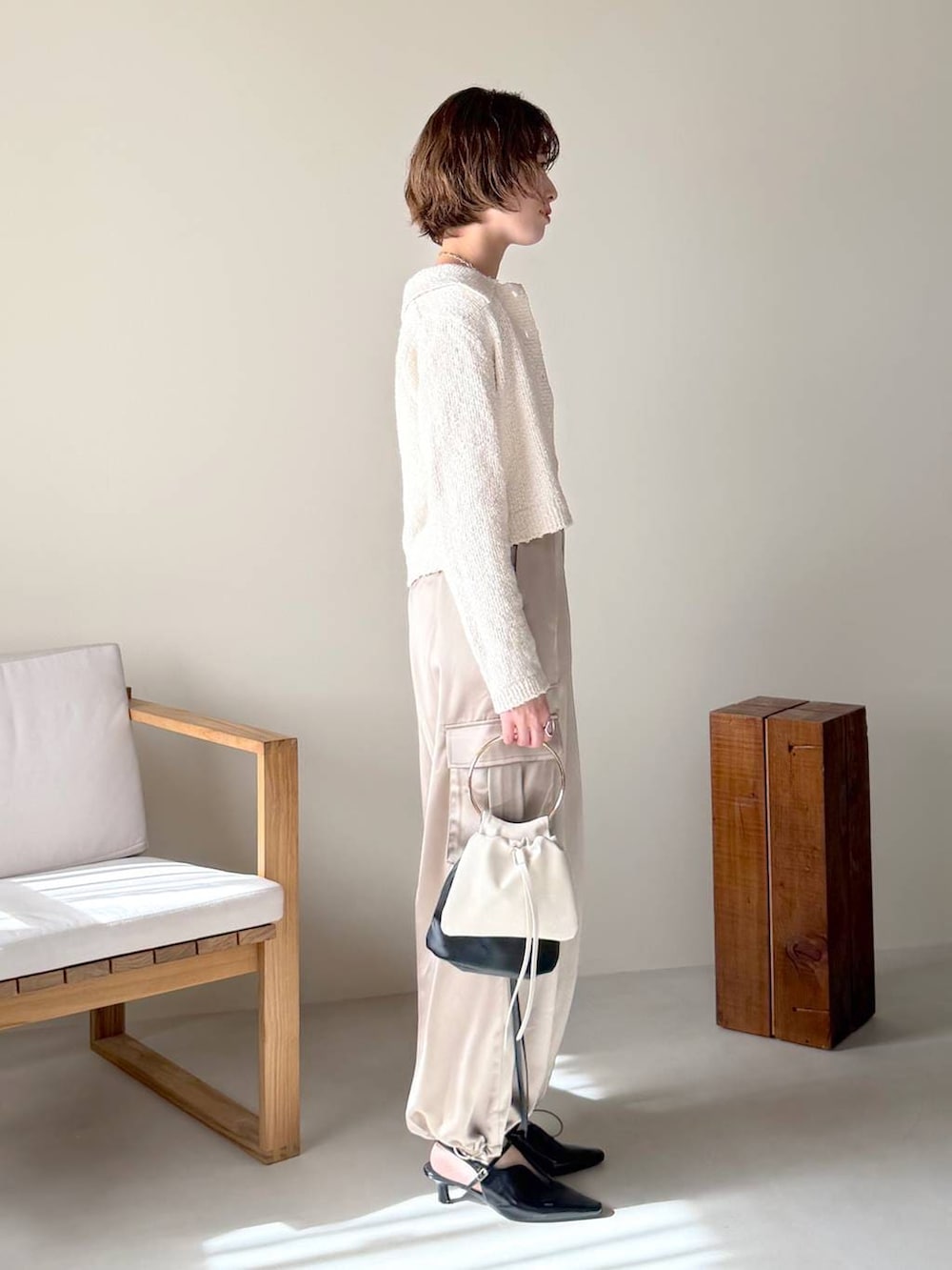 ブラック系のサンダル、ホワイト系のカーディガン/ボレロ、ベージュ系のその他パンツを着用したレディースの冬コーディネートの2枚目の写真