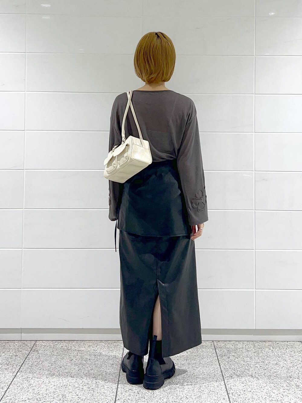 ブラック系のブーツ、グレー系のTシャツ/カットソー、ブラック系のスカートを着用したレディースの秋コーディネートの4枚目の写真