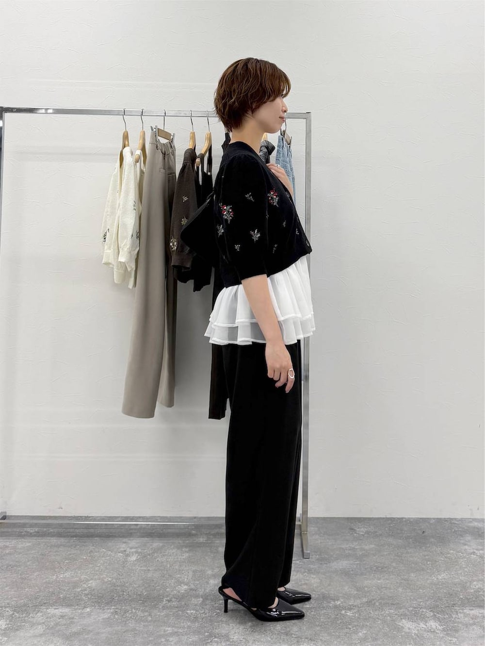 グレー系のニット/セーター、ブラック系のその他パンツ、ブラック系のカーディガン/ボレロを着用したレディースの夏コーディネートの2枚目の写真