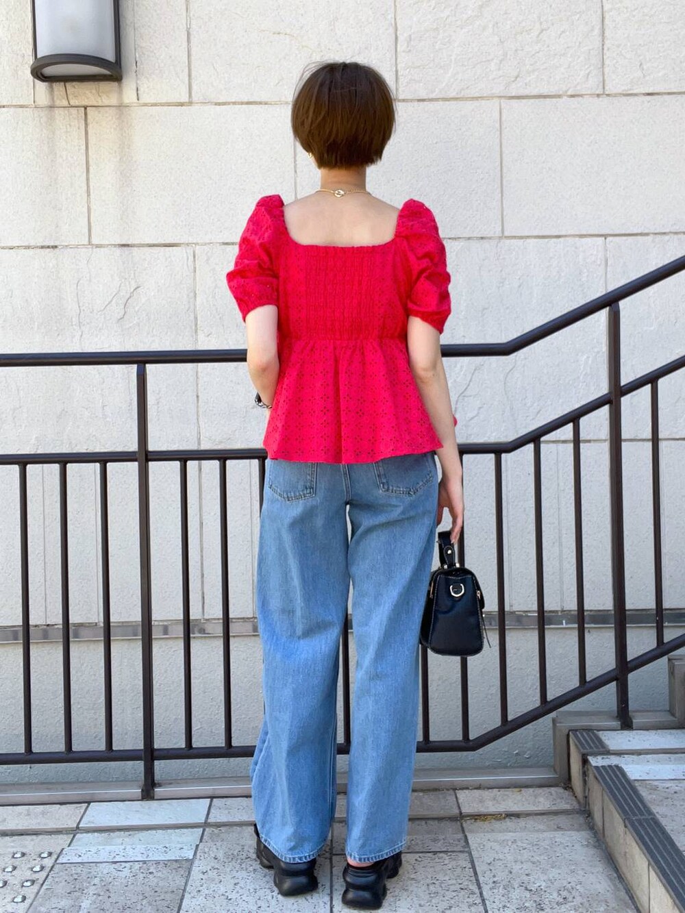 ブルー系のデニムパンツ、ブラック系のサンダル、ブラック系のショルダーバッグを着用したレディースの夏コーディネートの3枚目の写真