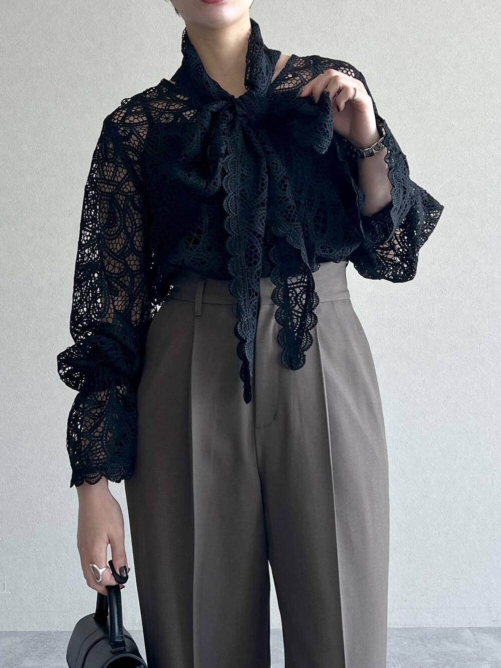 ブラック系のシャツ/ブラウス、ブラウン系のスラックス、ブラック系のローファーを着用したレディースの秋コーディネートの4枚目の写真