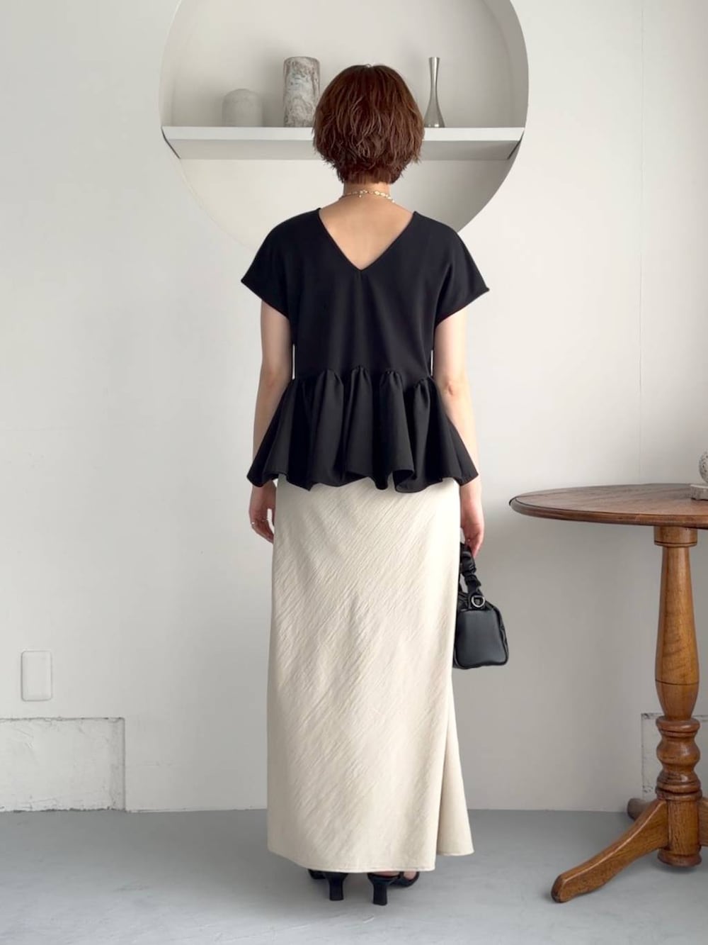 ブラック系のサンダル、ベージュ系のスカート、ブラック系のショルダーバッグを着用したレディースの夏コーディネートの4枚目の写真