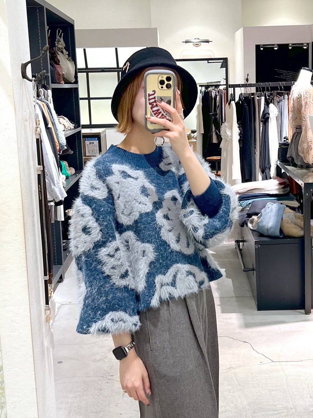 ブルー系のニット/セーター、ブラック系のショルダーバッグ、ブラック系のブーツを着用したレディースの秋コーディネートの6枚目の写真