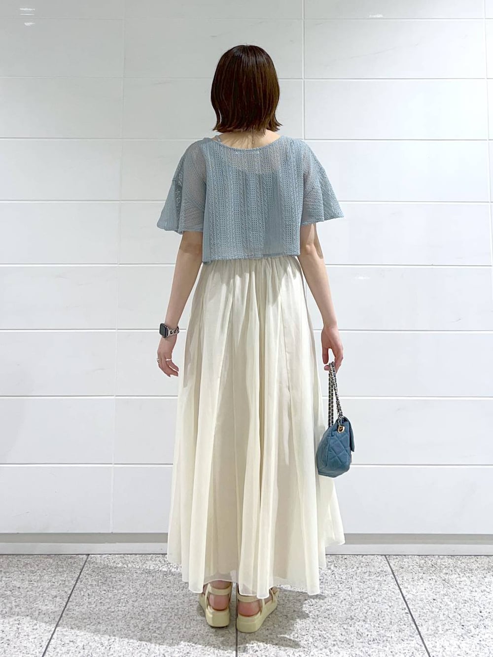 ホワイト系のサンダル、ブルー系のショルダーバッグ、ホワイト系のスカートを着用したレディースの春コーディネートの4枚目の写真