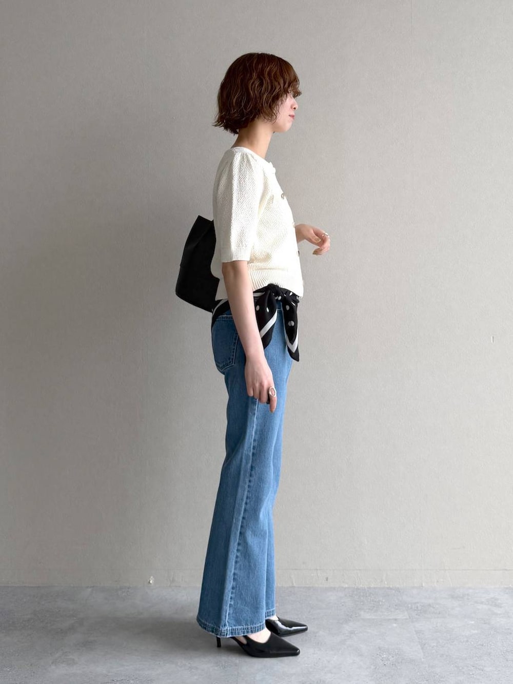 ホワイト系のカーディガン/ボレロ、ブルー系のデニムパンツ、ブラック系のサンダルを着用したレディースの春コーディネートの2枚目の写真