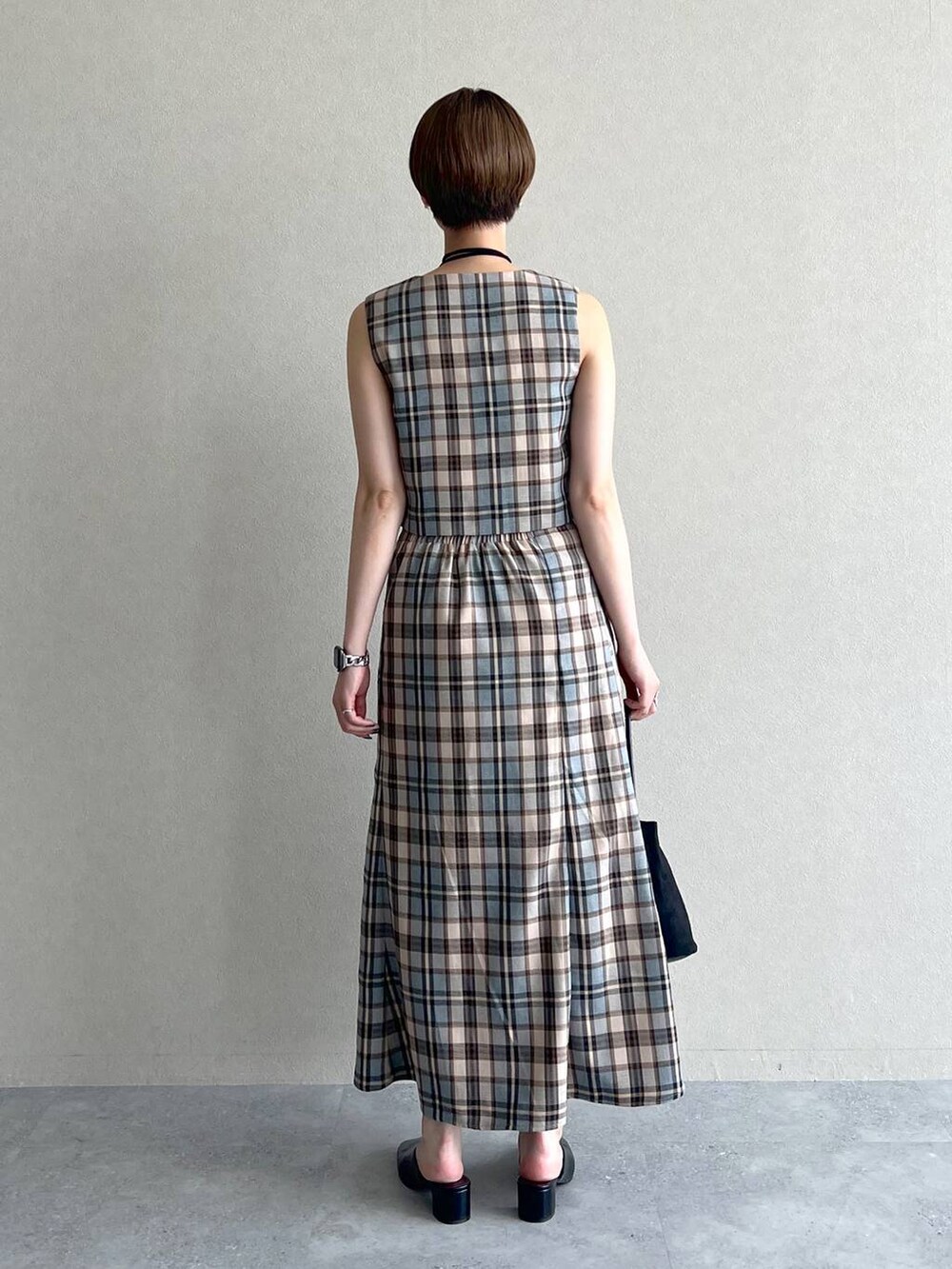 ブラック系のスリッポン、ブラック系のキャミソール、ブラック系のハンドバッグを着用したレディースの秋コーディネートの4枚目の写真