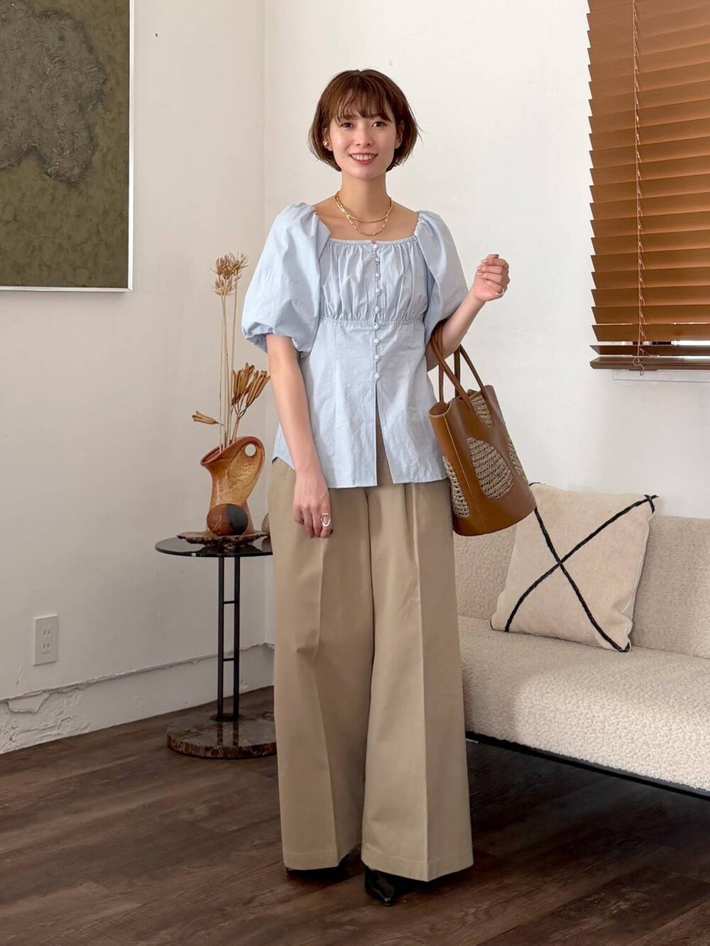 ブラウン系のトートバッグ、ブラック系のサンダル、ベージュ系のチノパンツを着用したレディースの春コーディネートの5枚目の写真