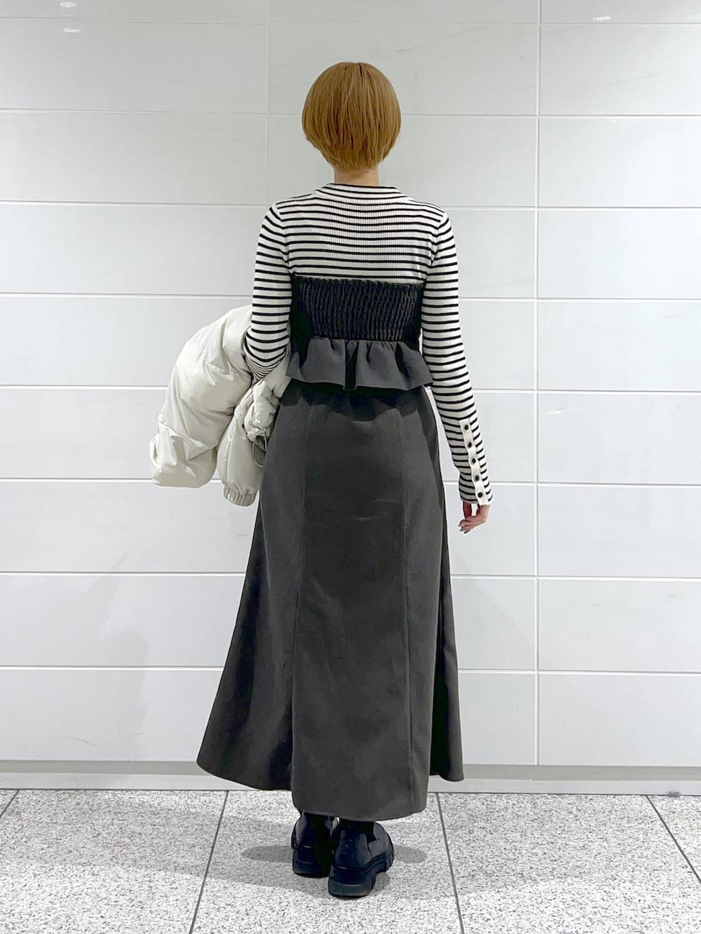 ブラック系のブーツ、ブラック系のニット/セーター、ホワイト系のブルゾンを着用したレディースの冬コーディネートの6枚目の写真