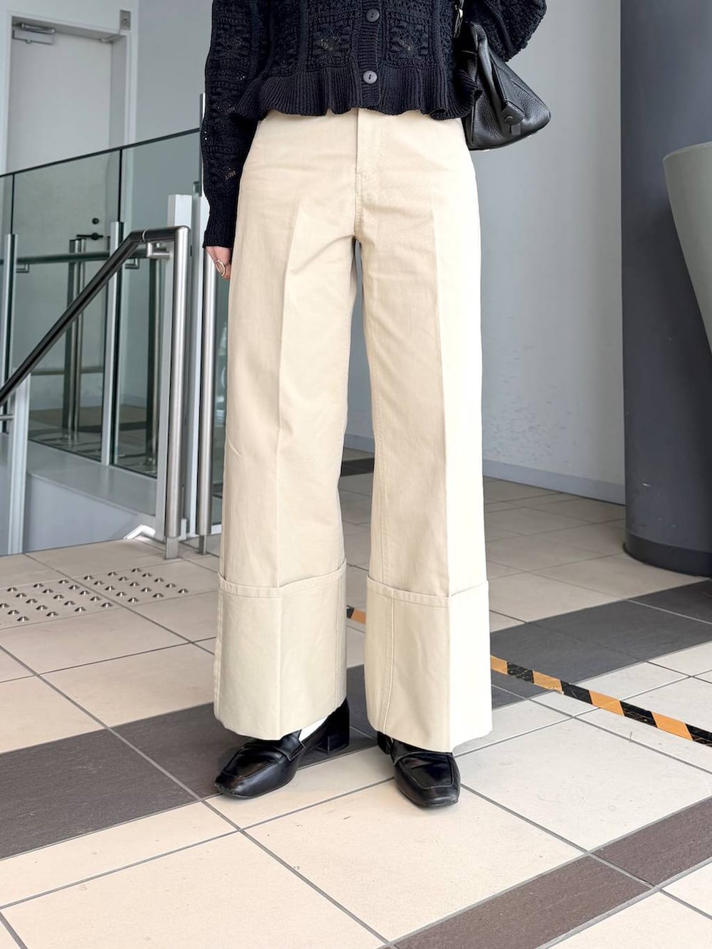 ブラック系のハンドバッグ、ブラック系のローファー、ブラック系のカーディガン/ボレロを着用したレディースの冬コーディネートの6枚目の写真