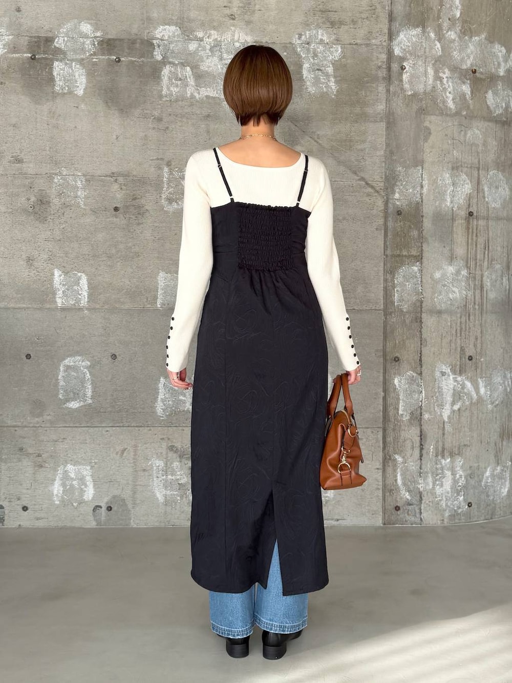 ブラウン系のボストンバッグ、ブラック系のローファー、ブルー系のデニムパンツを着用したレディースの冬コーディネートの3枚目の写真