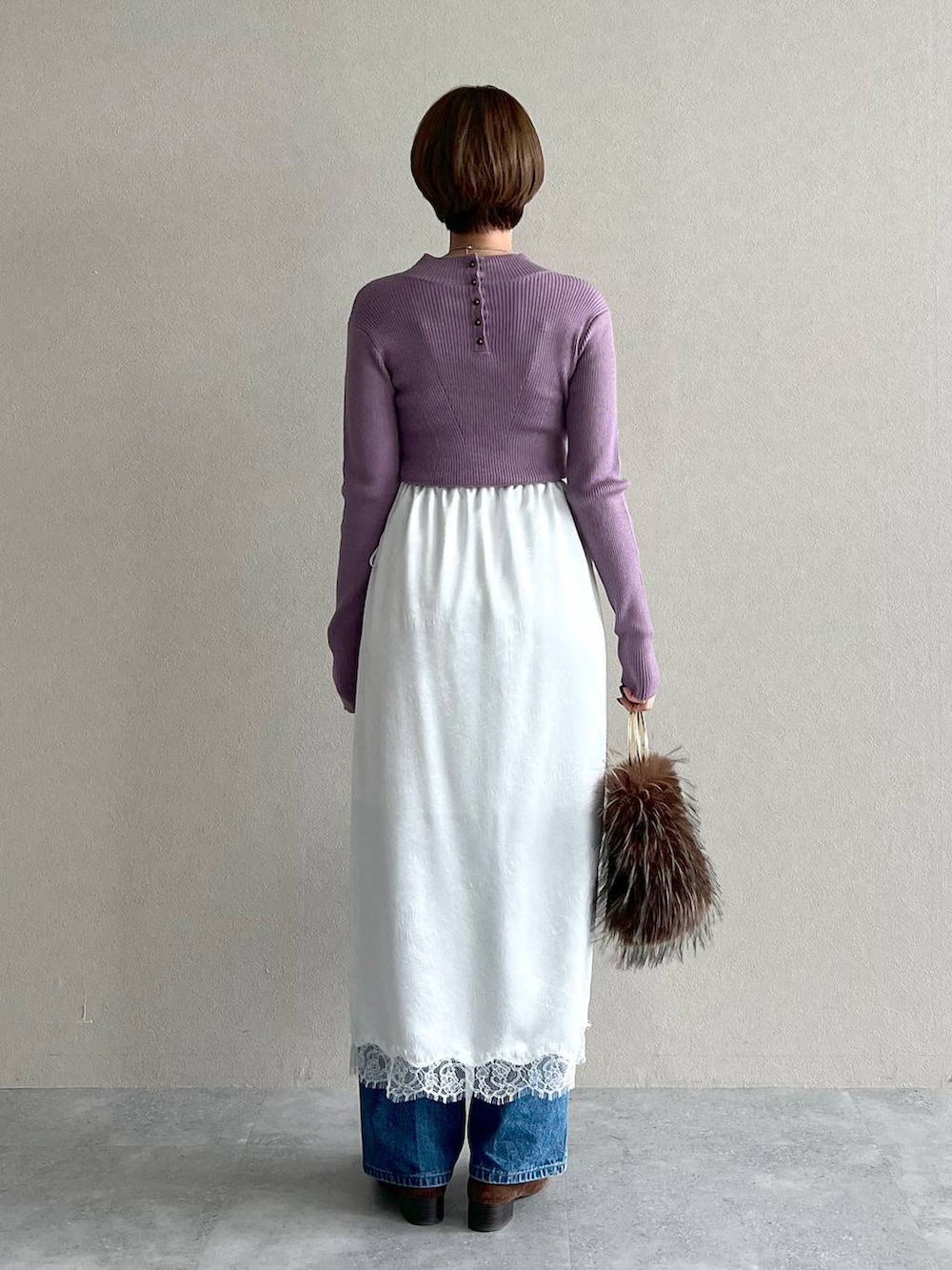 パープル系のニット/セーター、ブルー系のデニムパンツ、ブラウン系のローファーを着用したレディースの秋コーディネートの3枚目の写真