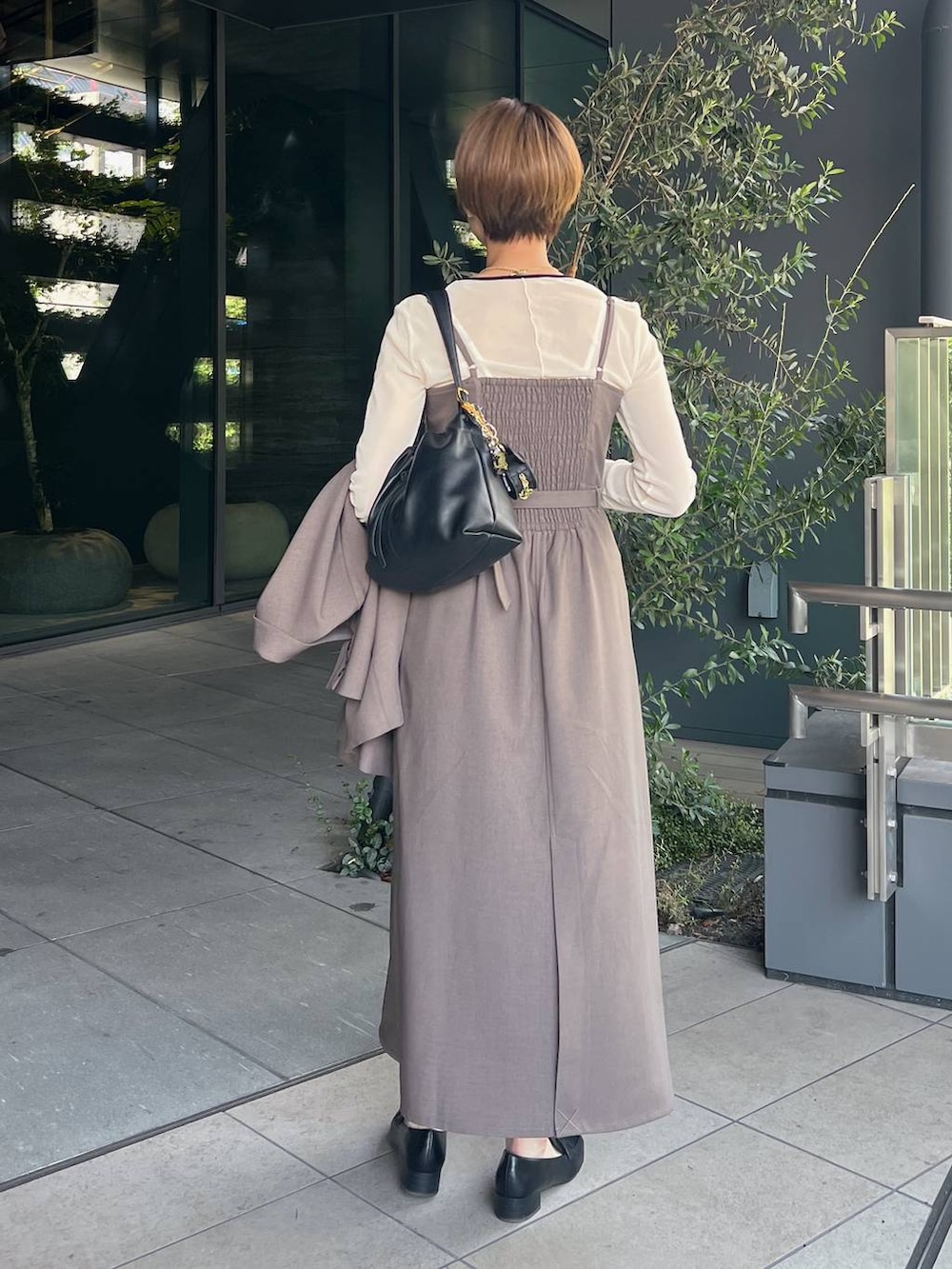 ホワイト系のTシャツ/カットソー、ブラック系のローファー、ベージュ系のワンピースを着用したレディースの秋コーディネートの6枚目の写真