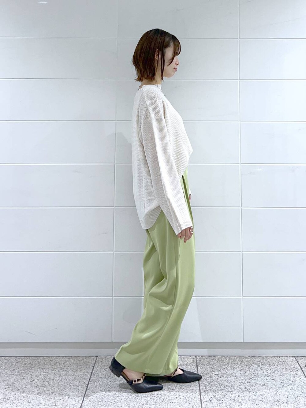 ホワイト系のTシャツ/カットソー、グリーン系のスラックス、ブラック系のショルダーバッグを着用したレディースの春コーディネートの2枚目の写真