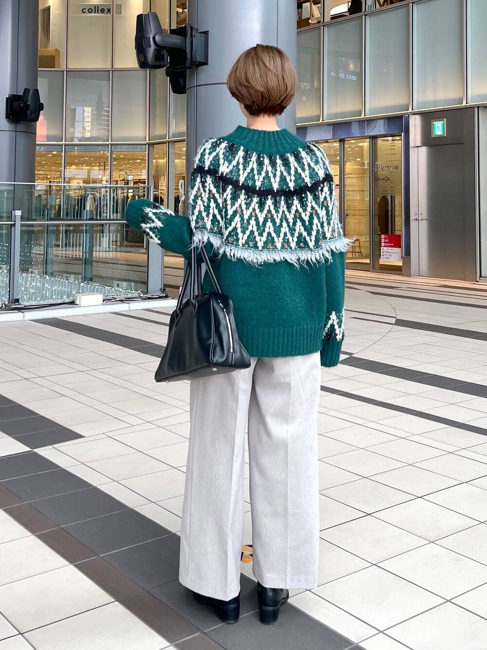 ブラック系のトートバッグ、ブラック系のブーツ、グリーン系のニット/セーターを着用したレディースの秋コーディネートの3枚目の写真