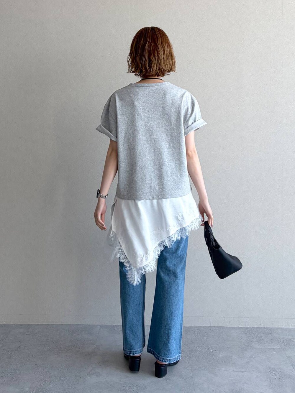 ブルー系のデニムパンツ、グレー系のTシャツ/カットソー、ブラック系のショルダーバッグを着用したレディースの春コーディネートの3枚目の写真