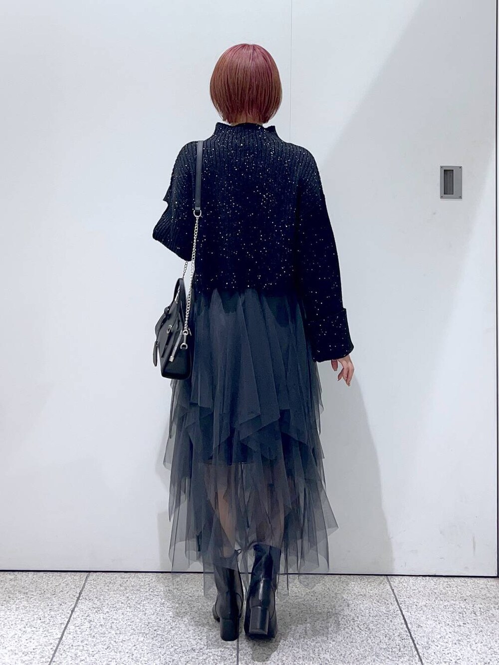 ブラック系のボストンバッグ、ブラック系のブーツ、ブラック系のニット/セーターを着用したレディースの秋コーディネートの3枚目の写真