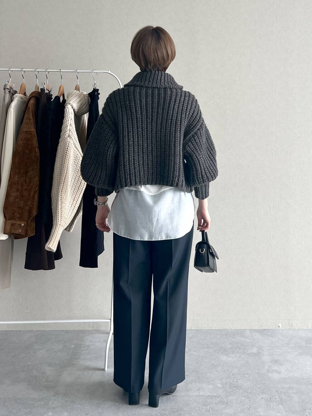 ブルー系のスラックス、ホワイト系のTシャツ/カットソー、ブラック系のブーツを着用したレディースの秋コーディネートの3枚目の写真