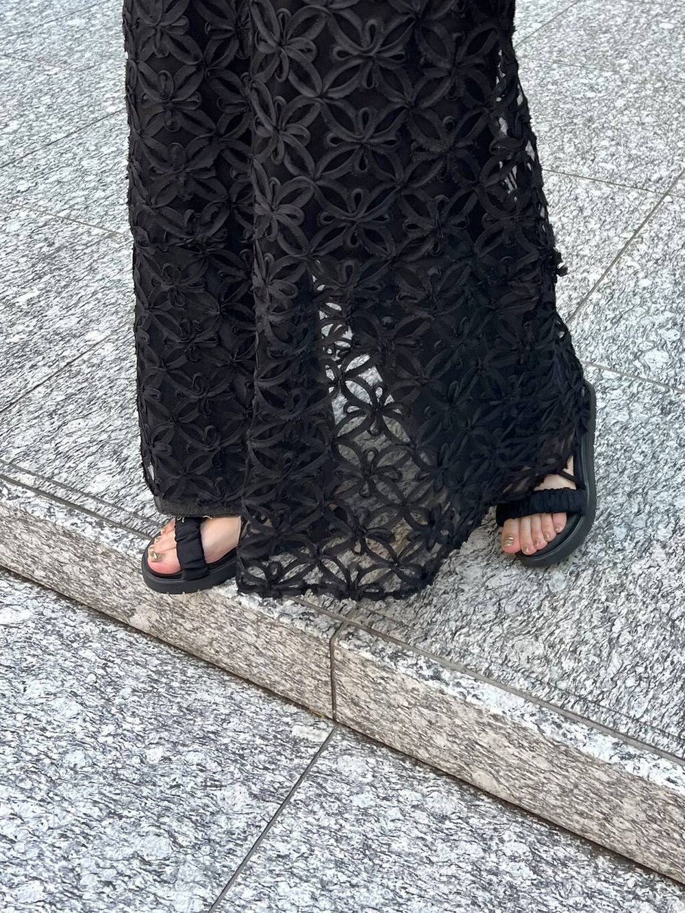 ブラック系のサンダル、ブラック系のショルダーバッグ、ホワイト系のTシャツ/カットソーを着用したレディースの夏コーディネートの5枚目の写真