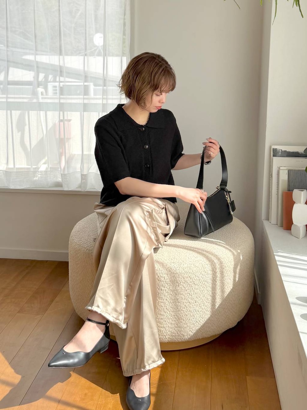 ブラック系のパンプス、ブラック系のショルダーバッグ、ベージュ系のその他パンツを着用したレディースの春コーディネートの4枚目の写真