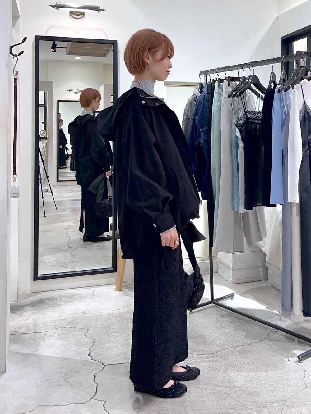 ブラック系のショルダーバッグ、ブラック系のマウンテンパーカー、ブラック系のバレエシューズを着用したレディースの春コーディネートの2枚目の写真