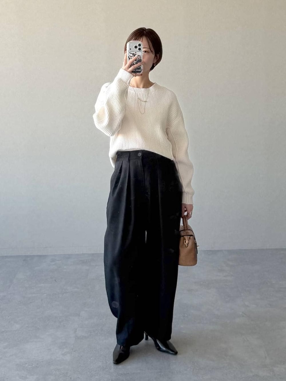 ブラック系のローファー、ブラウン系のショルダーバッグ、ホワイト系のニット/セーターを着用したレディースの冬コーディネートの5枚目の写真