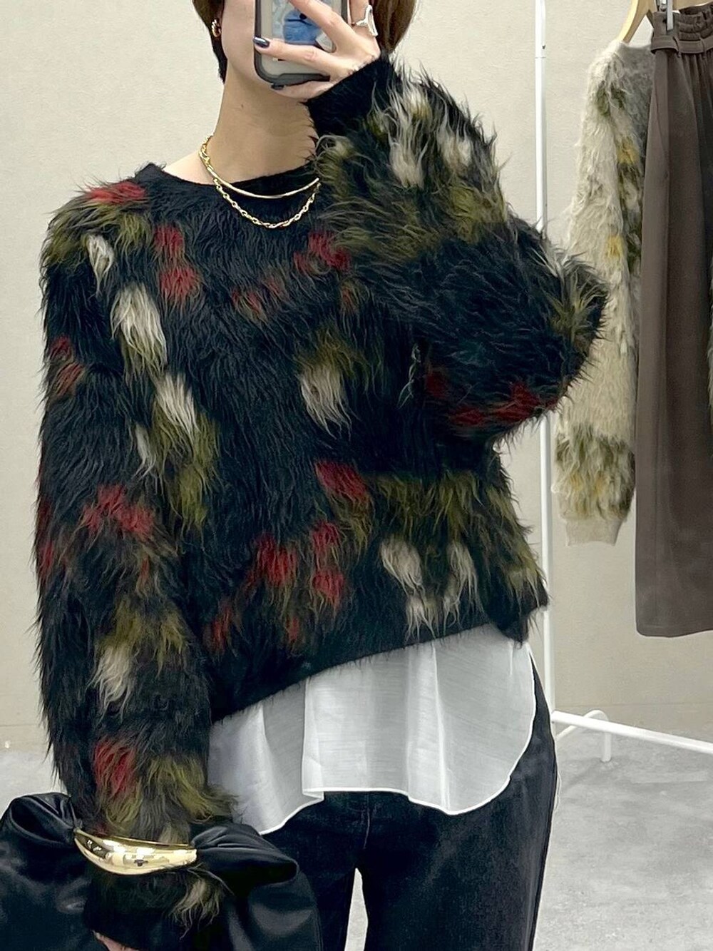 ブラック系のハンドバッグ、グレー系のデニムパンツ、ブラック系のローファーを着用したレディースの秋コーディネートの4枚目の写真