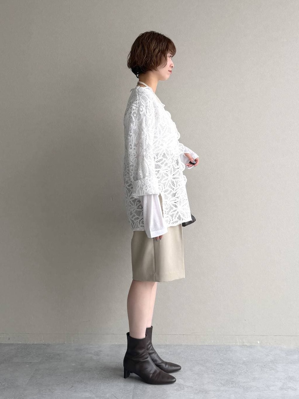 ホワイト系のTシャツ/カットソー、ブラウン系のブーツ、ブラウン系のトートバッグを着用したレディースの冬コーディネートの2枚目の写真