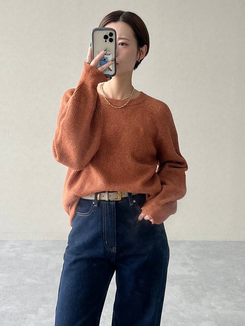 ブラウン系のノーカラージャケット、ブルー系のデニムパンツ、オレンジ系のニット/セーターを着用したレディースの秋コーディネートの5枚目の写真