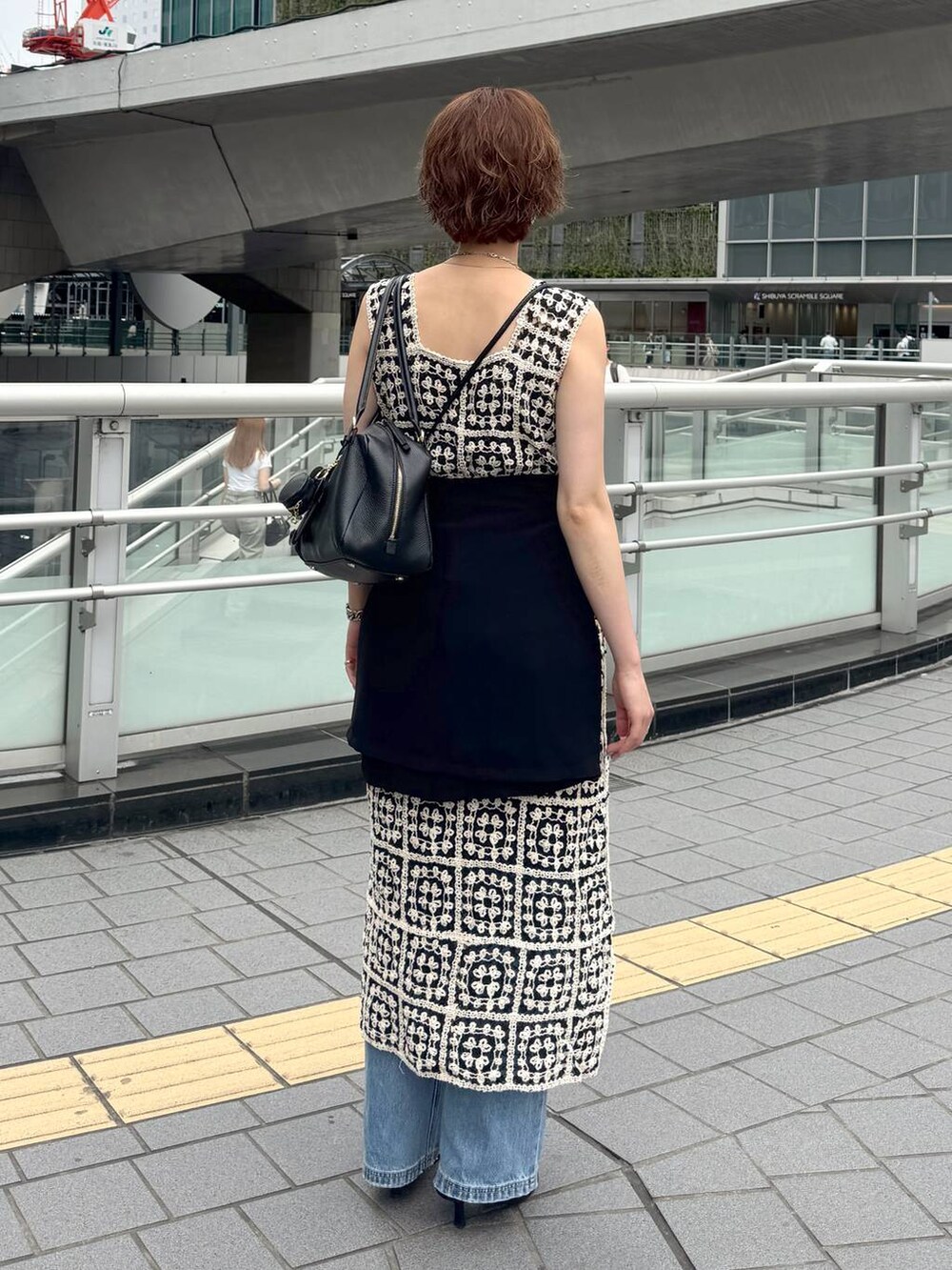 その他のワンピース、ブラック系のハンドバッグ、ブルー系のデニムパンツを着用したレディースの夏コーディネートの3枚目の写真