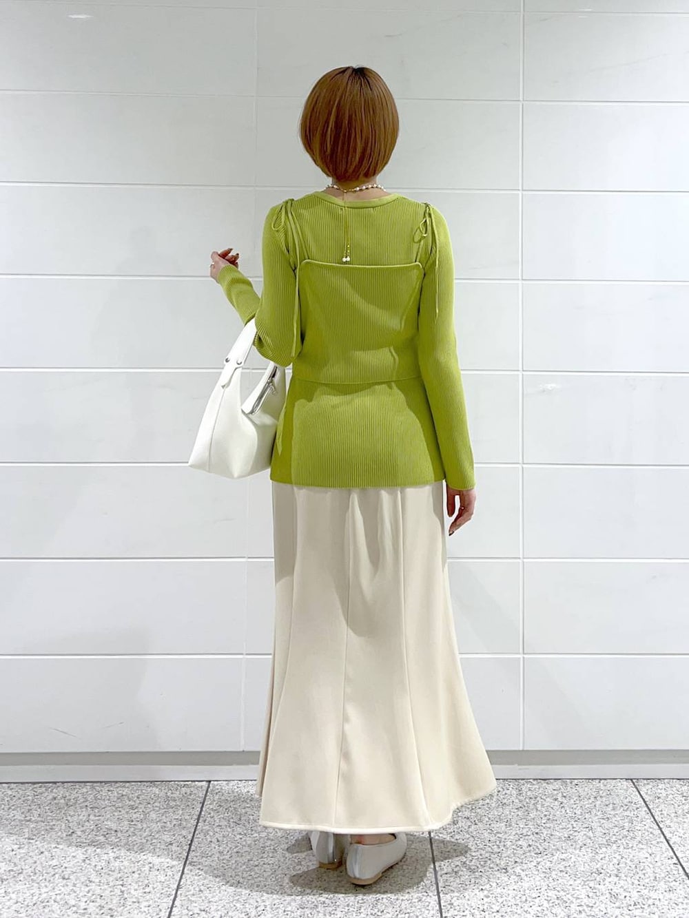 ベージュ系のスカート、シルバー系のバレエシューズ、グリーン系のカーディガン/ボレロを着用したレディースの春コーディネートの3枚目の写真