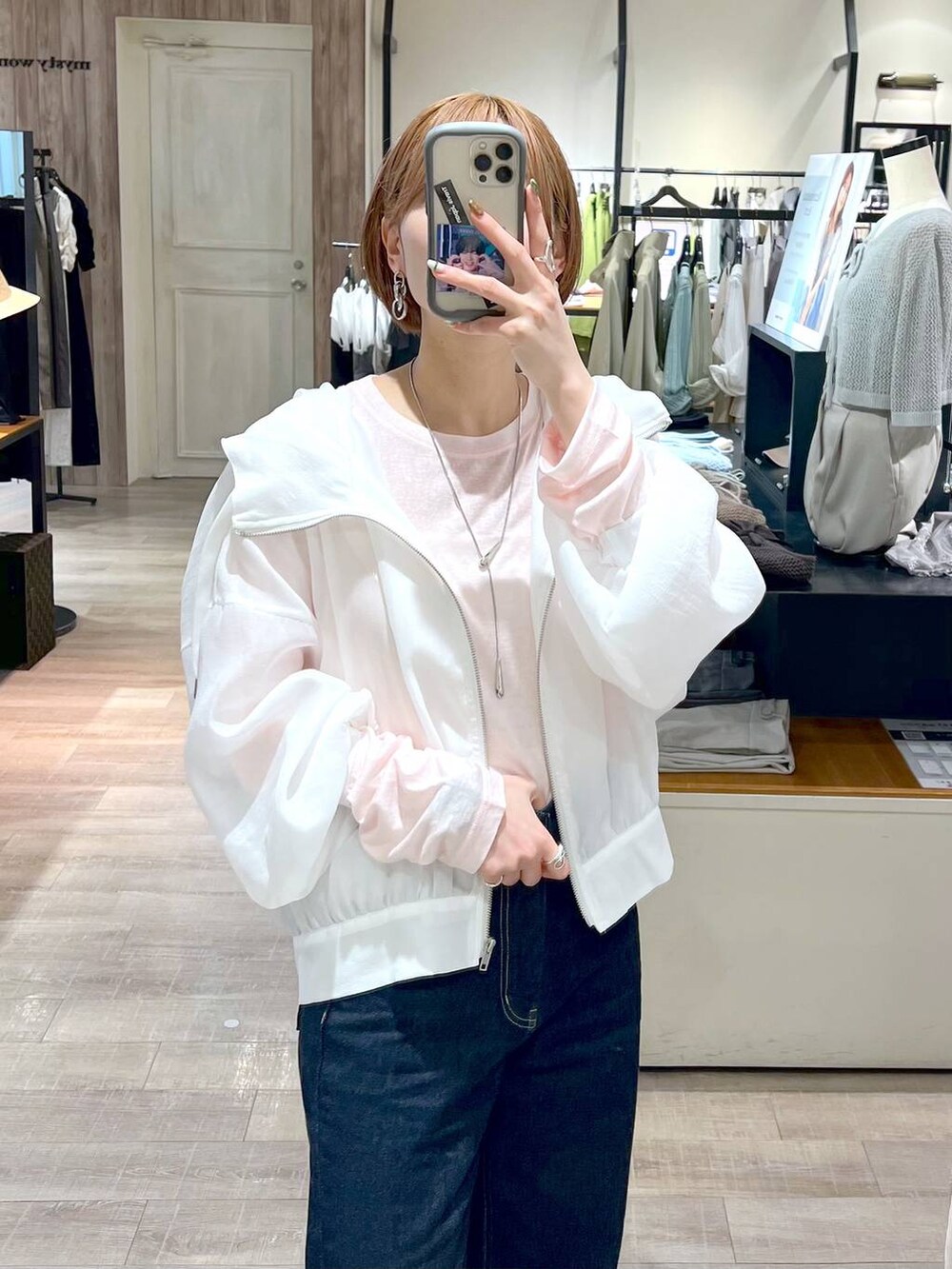 ブルー系のデニムパンツ、ホワイト系のブルゾン、ホワイト系のバレエシューズを着用したレディースの春コーディネートの4枚目の写真