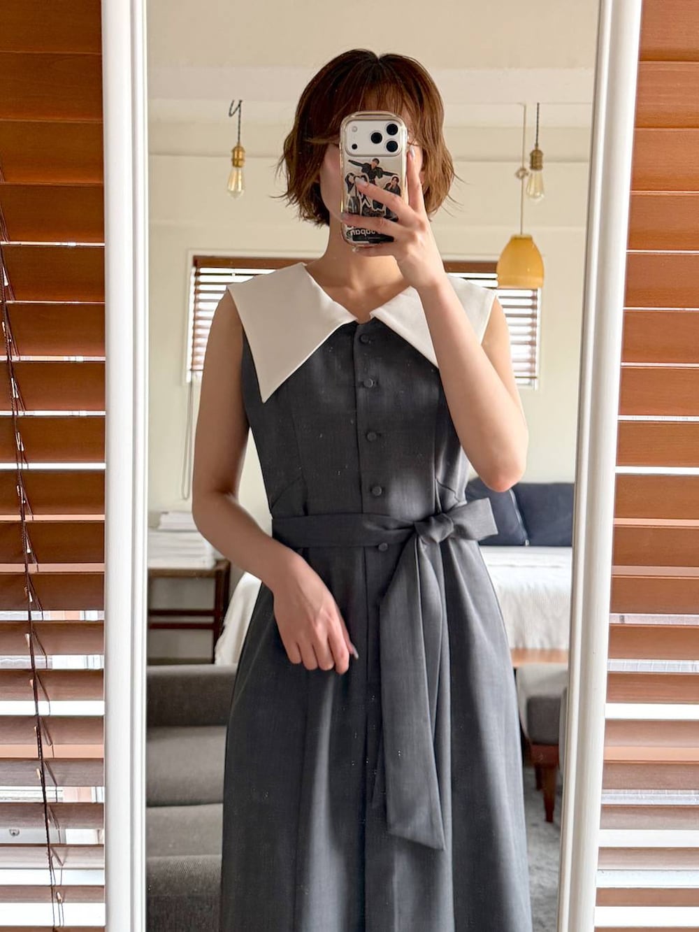 ブラック系のハンドバッグ、ブラック系のサンダル、グレー系のワンピースを着用したレディースの春コーディネートの6枚目の写真