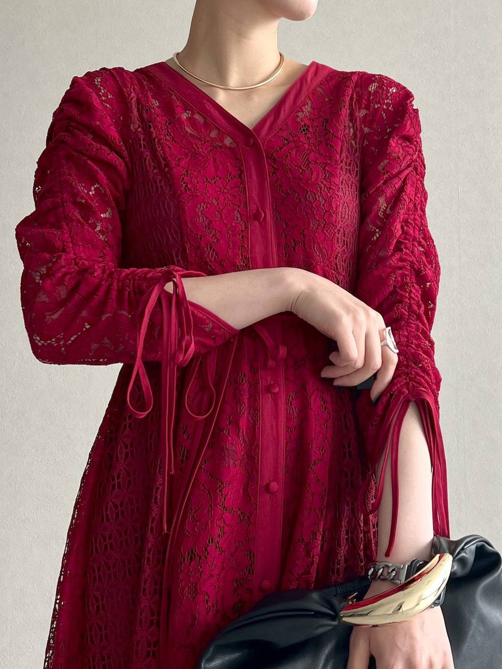 ブラック系のブルゾン、ブラック系のハンドバッグ、レッド系のワンピースを着用したレディースの秋コーディネートの8枚目の写真