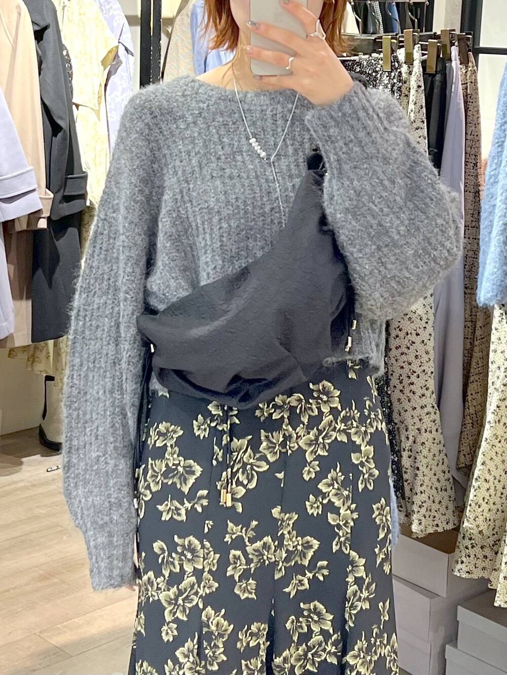 ブラック系のハンドバッグ、ブラック系のブーツ、ブラック系のスカートを着用したレディースの秋コーディネートの4枚目の写真