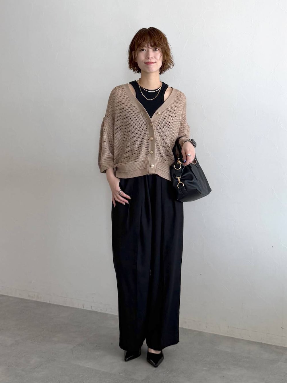 ブラック系のボストンバッグ、ブラック系のサンダル、ブラック系のタンクトップを着用したレディースの春コーディネートの6枚目の写真