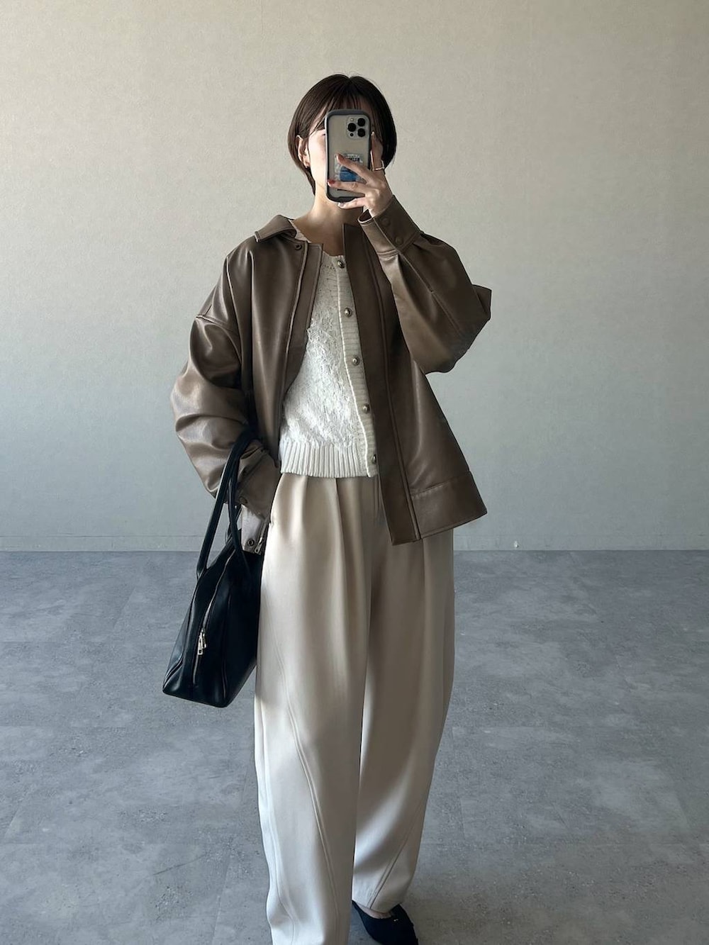 ブラック系のトートバッグ、ホワイト系のカーディガン/ボレロ、ブラック系のパンプスを着用したレディースの冬コーディネートの8枚目の写真