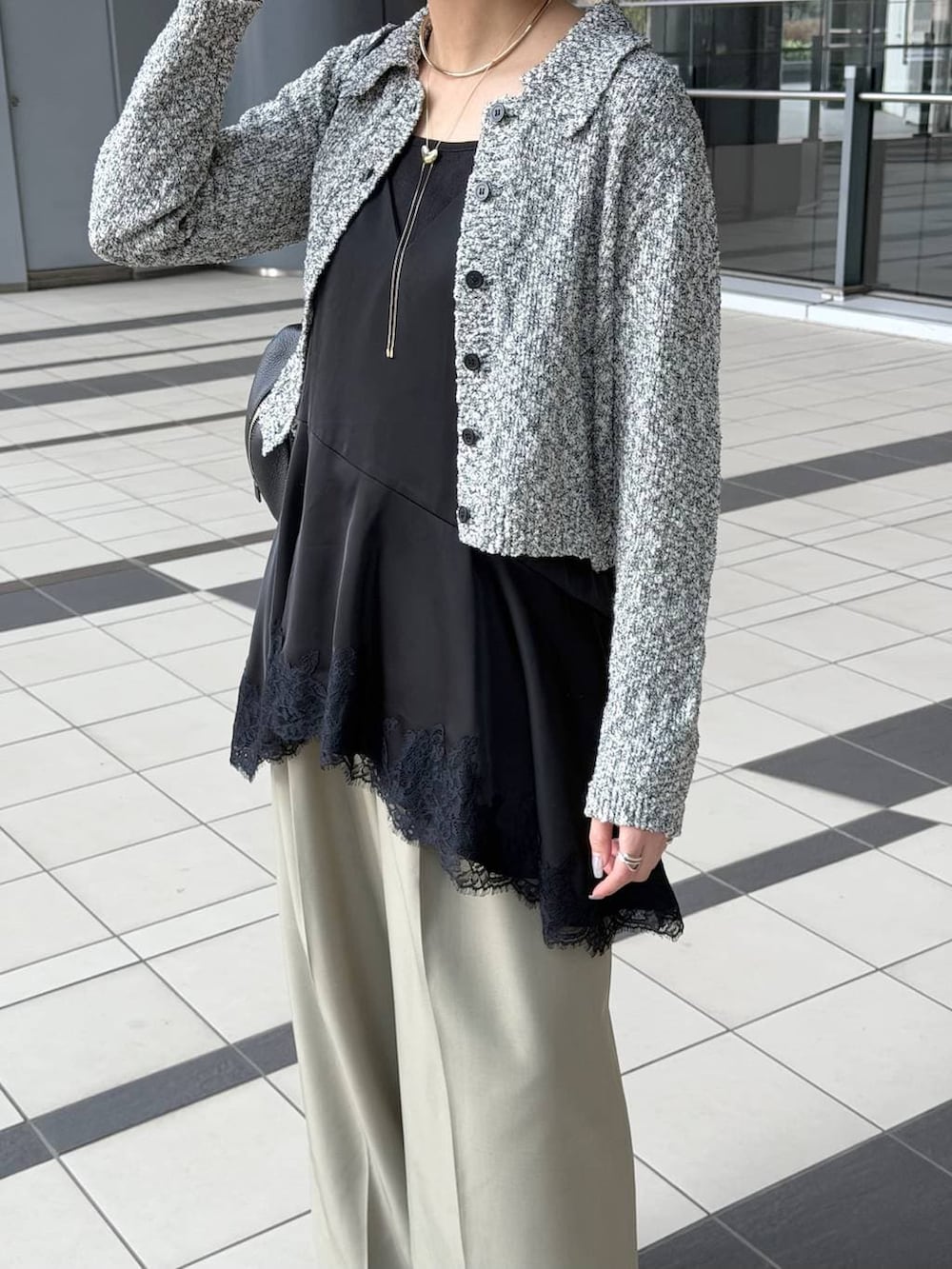 ブラック系のハンドバッグ、ブラック系のサンダル、ブラック系のキャミソールを着用したレディースの春コーディネートの4枚目の写真