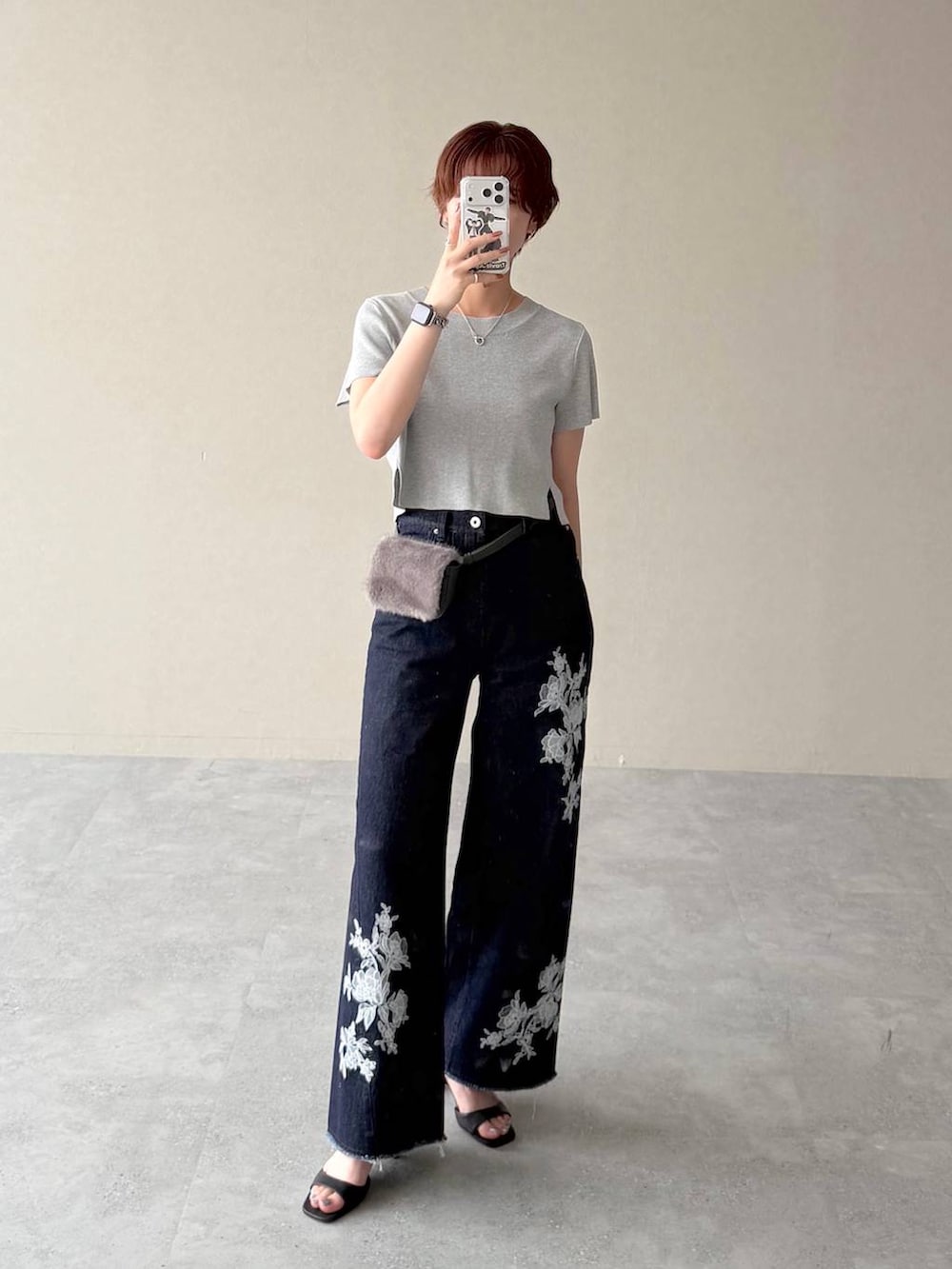 グレー系のニット/セーター、ブルー系のデニムパンツ、ブラック系のサンダルを着用したレディースの夏コーディネートの4枚目の写真