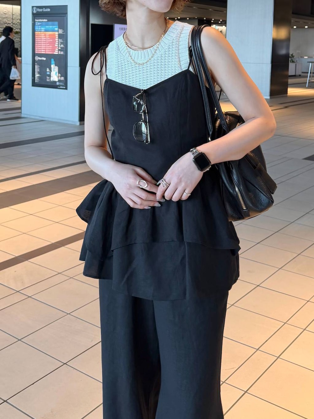 ブラック系のハンドバッグ、ブラック系のサンダル、ブラック系のシャツ/ブラウスを着用したレディースの春コーディネートの4枚目の写真