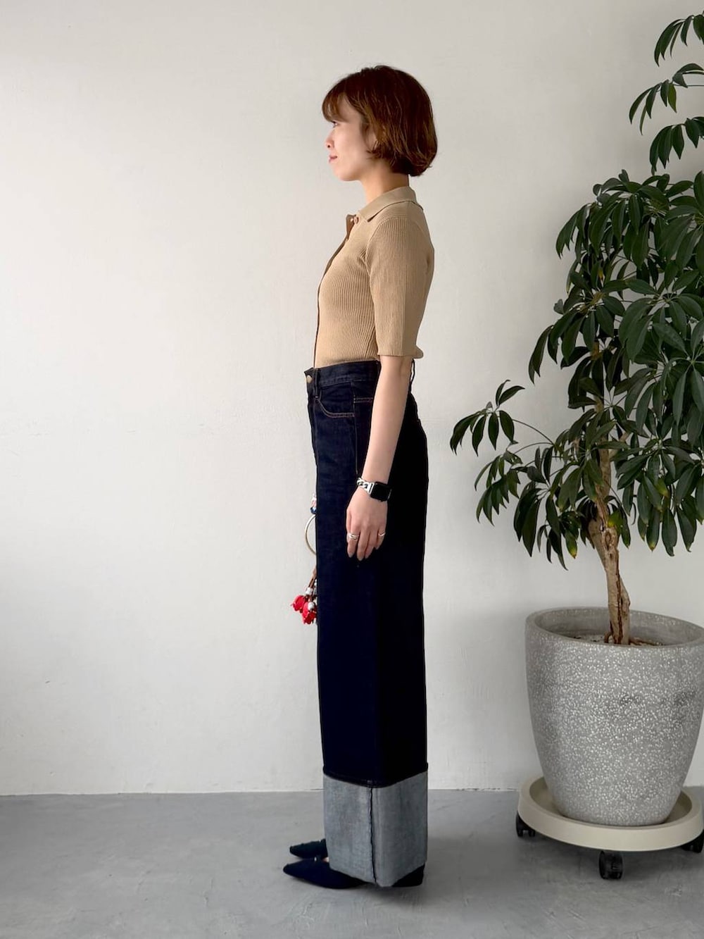 ブルー系のパンプス、ブラック系のショルダーバッグ、ブルー系のデニムパンツを着用したレディースの春コーディネートの2枚目の写真