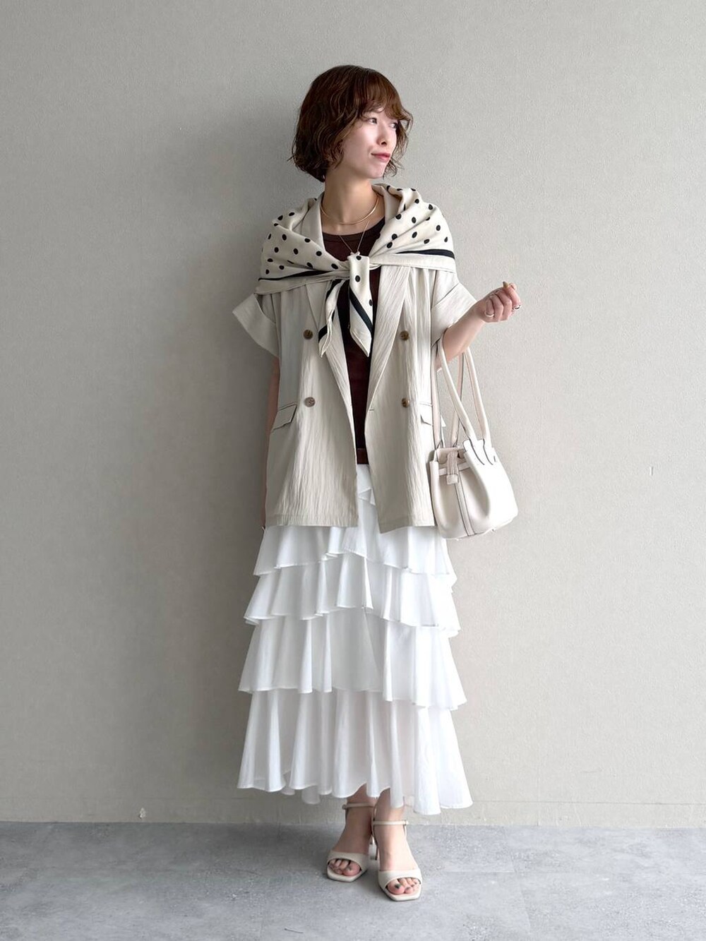 ホワイト系のサンダル、ブラウン系のTシャツ/カットソー、ホワイト系のスカートを着用したレディースの春コーディネートの7枚目の写真