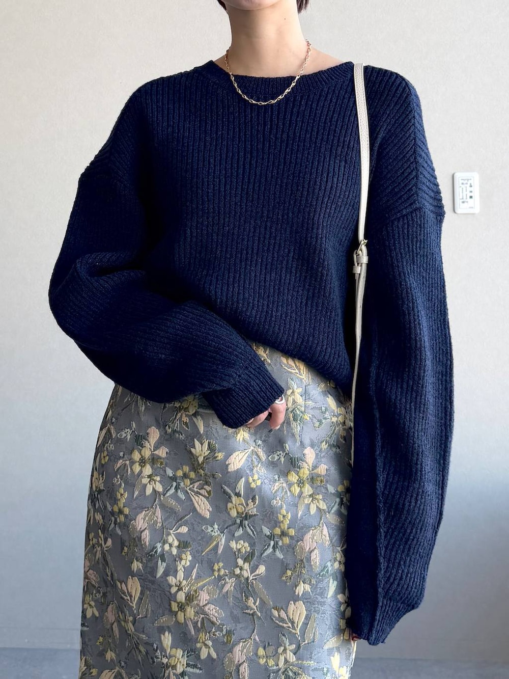 ホワイト系のショルダーバッグ、グレー系のスカート、ホワイト系のサンダルを着用したレディースの冬コーディネートの4枚目の写真