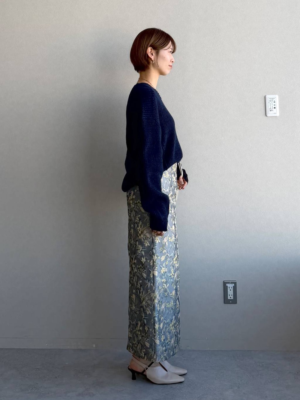 ホワイト系のショルダーバッグ、グレー系のスカート、ホワイト系のサンダルを着用したレディースの冬コーディネートの2枚目の写真