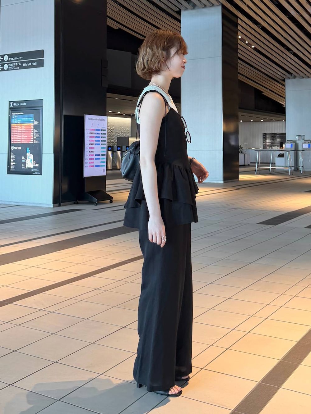 ブラック系のハンドバッグ、ブラック系のサンダル、ブラック系のシャツ/ブラウスを着用したレディースの春コーディネートの2枚目の写真