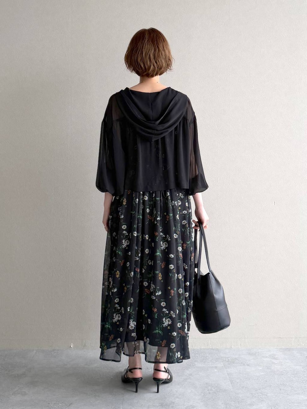 ブラック系のパーカー、ブラック系のサンダル、ブラック系のワンピースを着用したレディースの春コーディネートの3枚目の写真