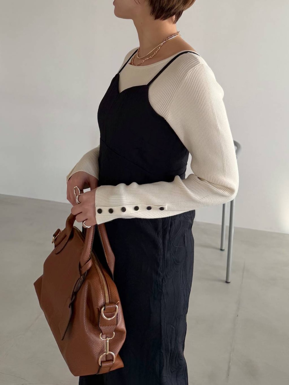 ブラウン系のボストンバッグ、ブラック系のローファー、ブルー系のデニムパンツを着用したレディースの冬コーディネートの4枚目の写真